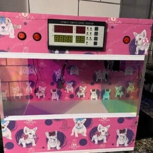 A pink machine with pictures of dogs on it.